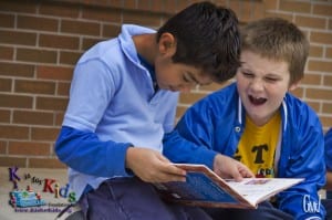 Two students at Golden Terrace Elementary enjoy the new books they chose during K is for Kids' Big Book Giveaway at their school